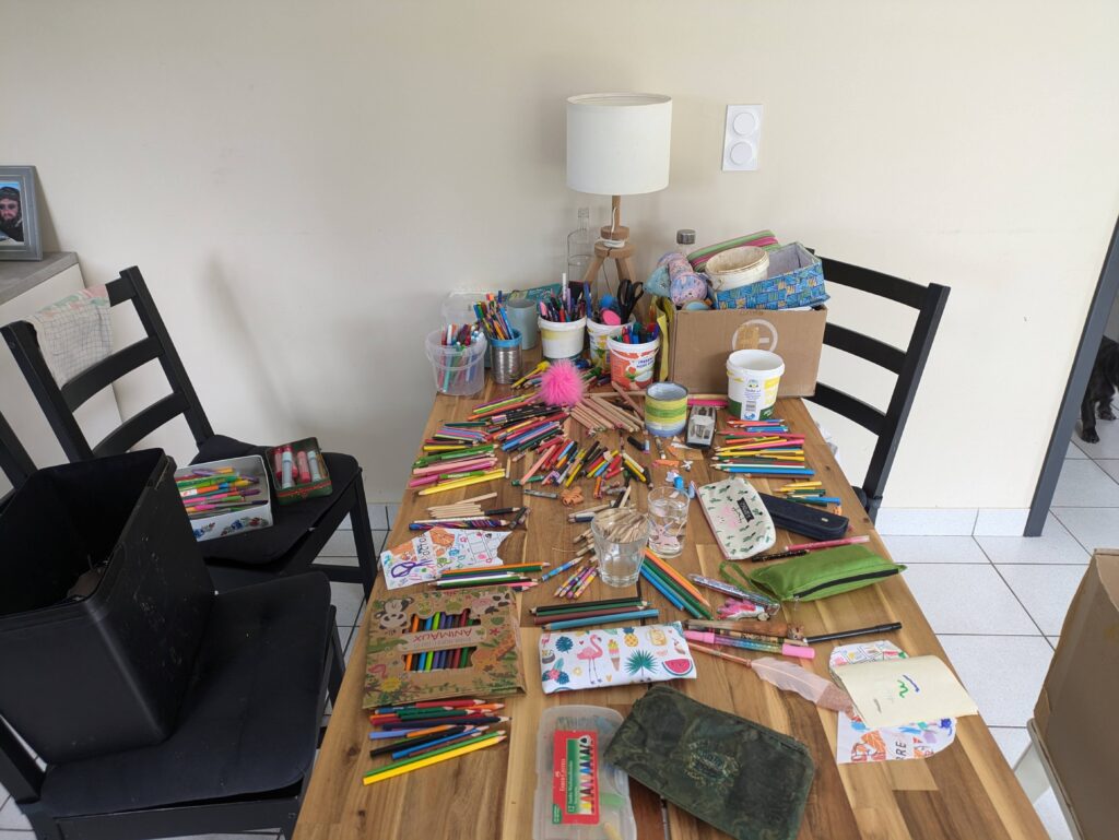 A mess of pens, pencils, felt pens on our kitchen table